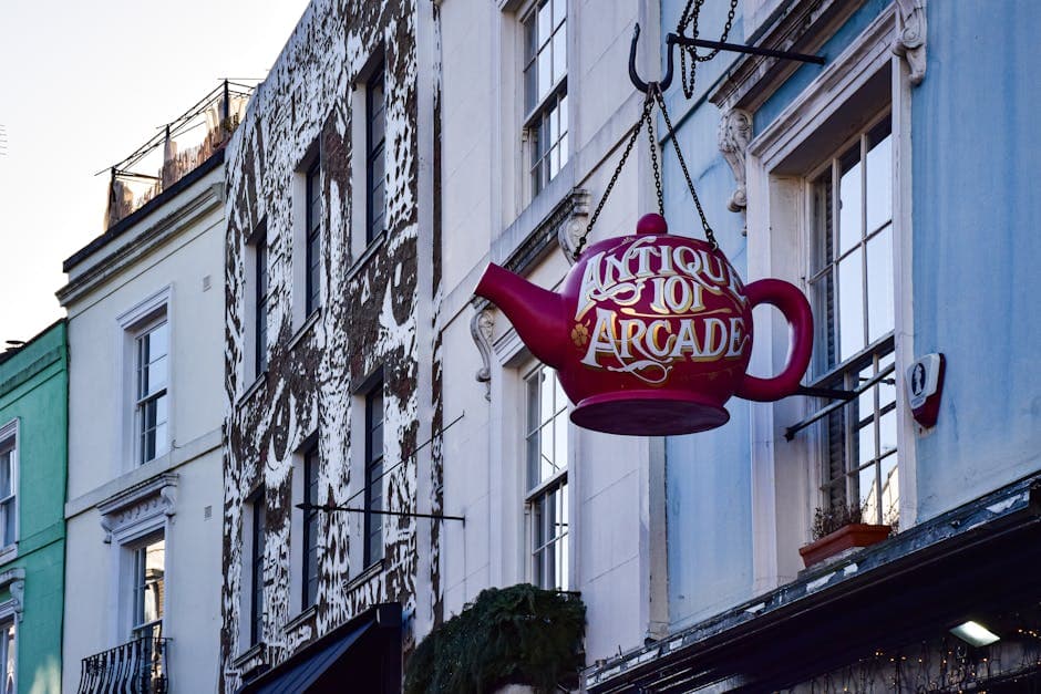 A colourful vintage sign hanging outside an independent shop on a characterful British street