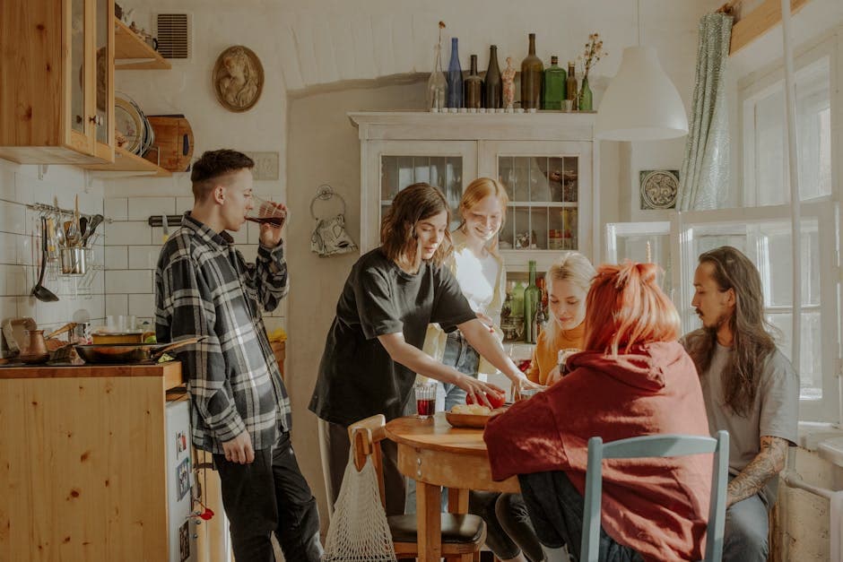Friends relaxing together in a bright kitchen, the communal atmosphere of a group apartment stay