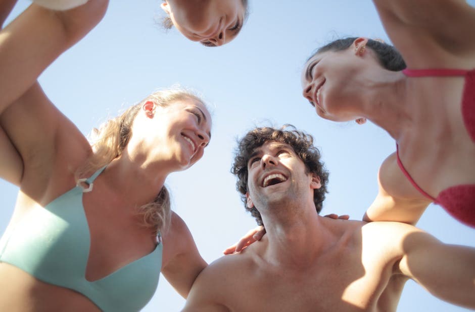 Group of friends in swimwear laughing together on a sunny day, celebrating a hen weekend