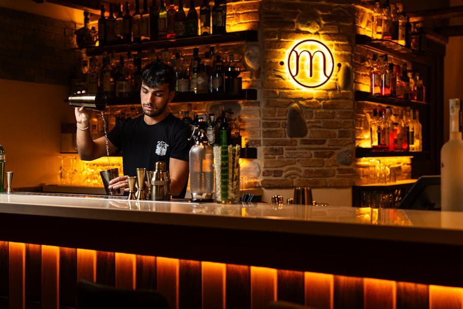 A bartender mixing cocktails in a stylish dimly lit bar creating a warm and inviting atmosphere