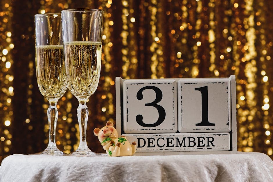 Festive New Year's Eve setup with champagne glasses and a calendar showing December 31st