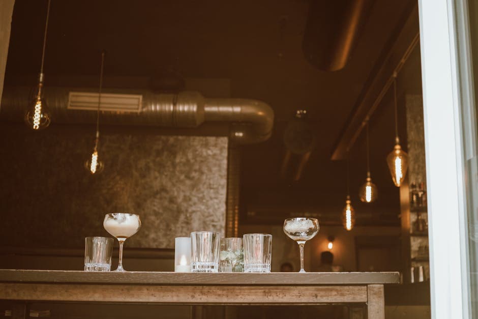 Stylish cocktail bar interior with industrial design and elegant lighting, glasses arranged on the bar