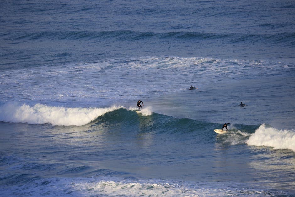 Boscombe beach with surfers in the water and the Coastal Activity Park visible on the seafront