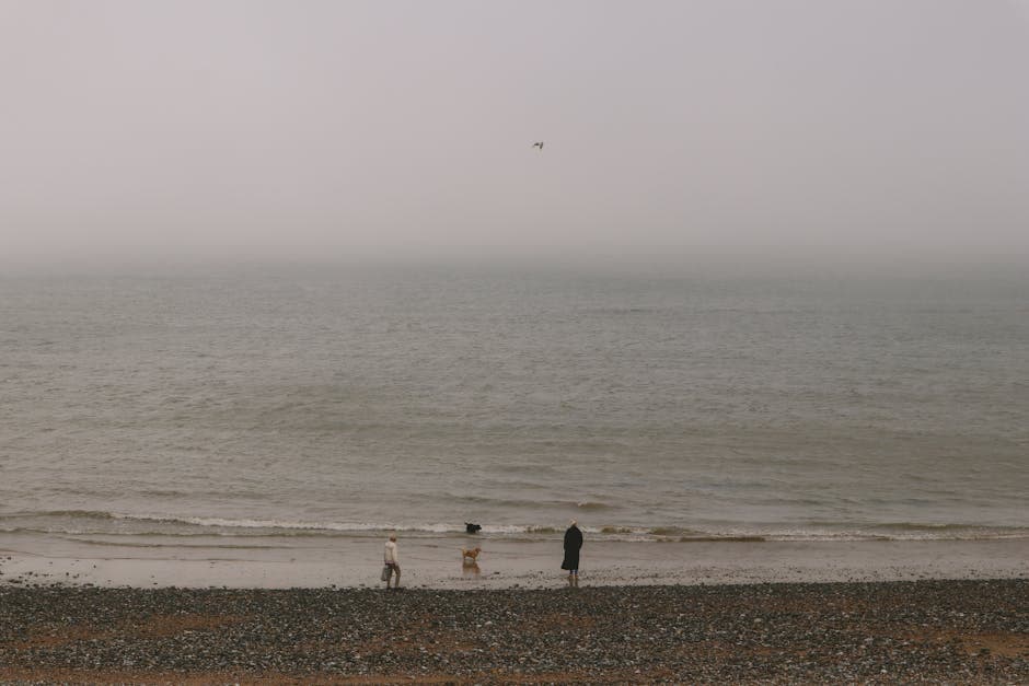 Empty Bournemouth beach in winter with dramatic clouds and a quiet promenade