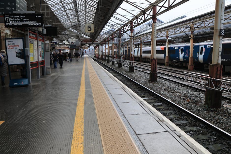 A busy train station platform in England with passengers waiting and a train alongside