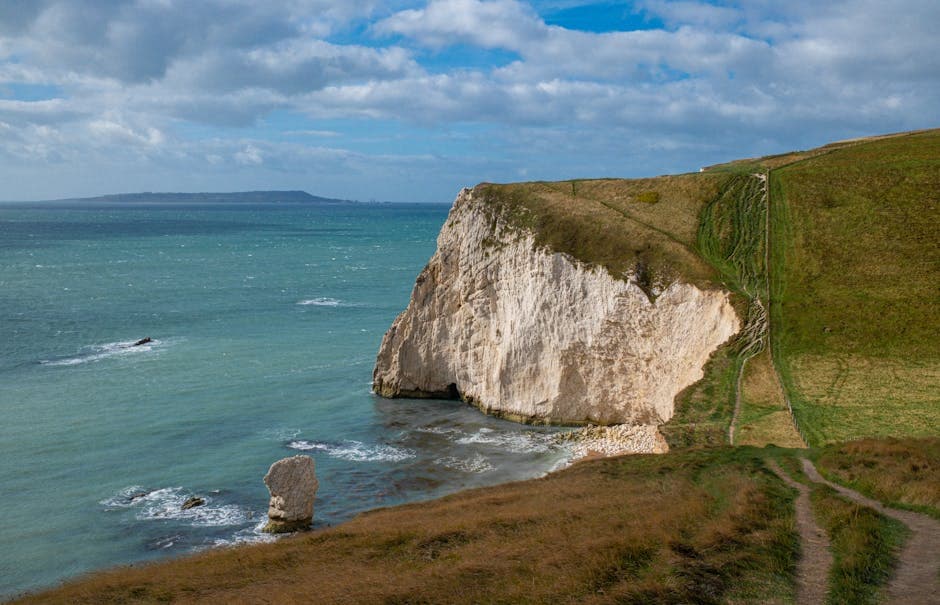 Dramatic cliffs along the Jurassic Coast in England with turquoise sea below and a clear blue sky