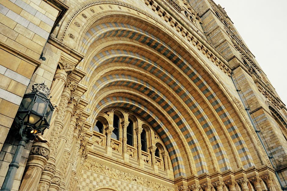 The ornate terracotta facade of a Victorian museum building with arched windows and elaborate stonework