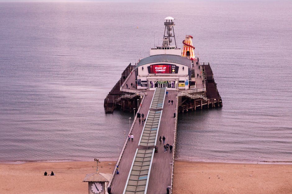 Aerial view of Bournemouth coastline showing the town centre, pier, and golden sandy beach stretching east towards Boscombe