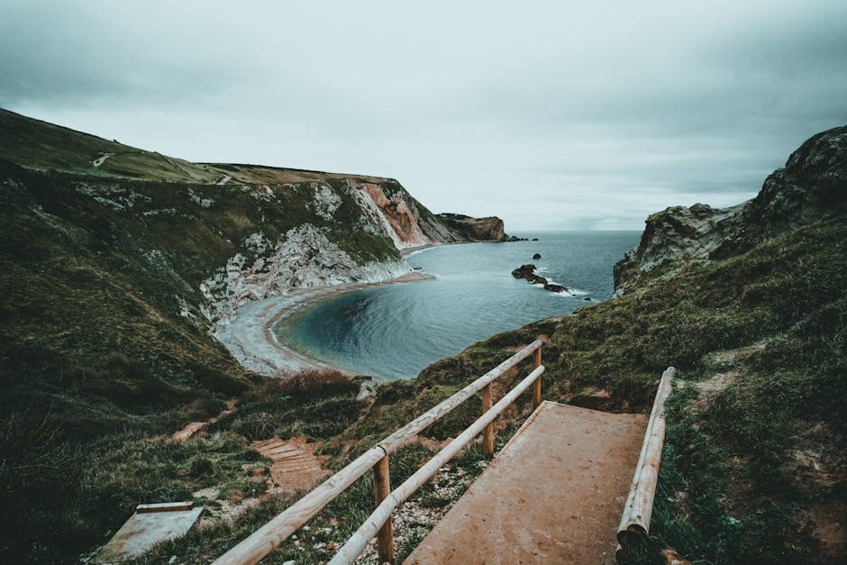 Dramatic Dorset clifftop views with green heathland dropping to a calm sea, characteristic of the coast east of Bournemouth towards Hengistbury Head