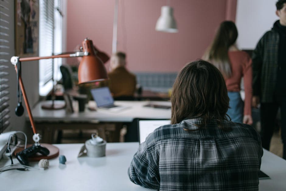 Modern coworking space with people working at desks in a collaborative open-plan environment